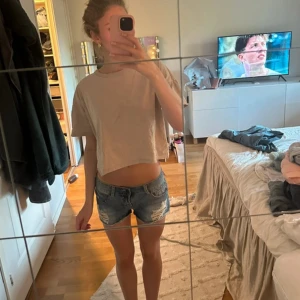 Blå jeansshorts med slitningar - Snygga blå jeansshorts med slitna detaljer och råa kanter. Klassiska och låg midja, perfekt till sommaren. De har en normal passform och är lätta att matcha med olika toppar.