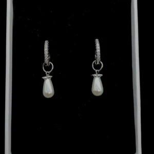 Glittriga örhängen med pärldroppar - Snygga örhängen i silverfärg med glittriga stenar på ringen och hängande droppformade pärlor. Ovanför pärlan sitter en liten stjärndetalj som ger extra charm. Perfekta för dig som vill sticka ut med en elegant och trendig look.