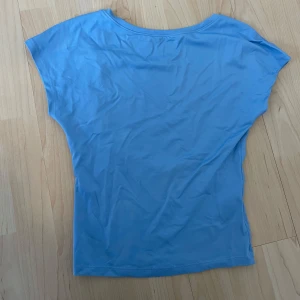  Blå topp med öppen rygg  - Säljer min helt oanvända topp med öppen rygg då den inte kommer till användning💕Tillverkad i ett mjukt och stretchigt tyg, perfekt för en fräsch och enkel look. Passar dig som gillar minimalistisk stil och vill ha något bekvämt och trendigt. 