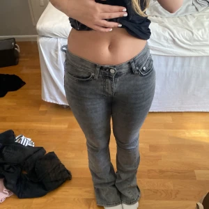 Grå bootcut jeans med slitna benslut - Säljer ett par grå jeans med midwaist, storlek 32, notera på slutet av benen är de sönder trampade