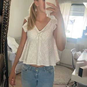 Vit blus - Supersöt vit blus med v-ringning, knyt framtill och volangärmar. 