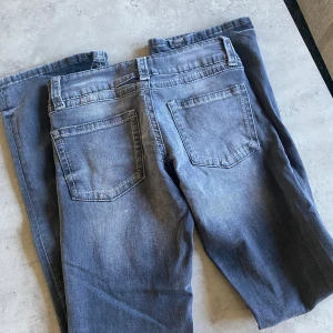 Low waist bootcut jeans - Gråa jeansen från Ginatricot. Storlek 158 och har för mig att det var i tall modellen. Byxorna är använda och finns defekter längs ner vid slutet av benen. Annars är de i bra skick! Lågmidjade.