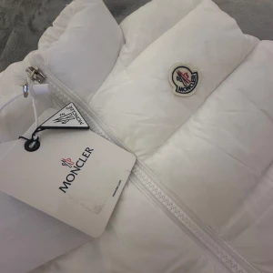 Vit dunväst från Moncler - Storleken passar folk som bär M. Den är helt ny och säljer den då den inte passa mig. Väldigt skön och fint material 🤩