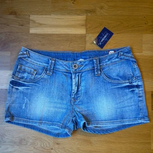 Low rise  jeansshorts med snygg tvätt  - Superfina low waist jeansshorts med snygga slitningar framtill och baktill. Köpta i Italien – unika och i väldigt fint skick! Ljus denimtvätt som passar perfekt till sommarens alla outfits 🌞.         📏 Midjemått (rakt över, liggande): ca 38 cm (= ca 76 cm omkrets – motsvarar ungefär storlek S/M)            