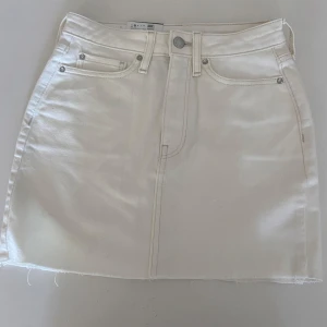Vit jeanskjol från Aurora, storlek S - Vit jeanskjol från Aurora i klassisk femficksmodell med rå kant nertill. Perfekt för dig som gillar en clean och stilren look. Nypris 299kr. Helt ny, aldrig använt!
