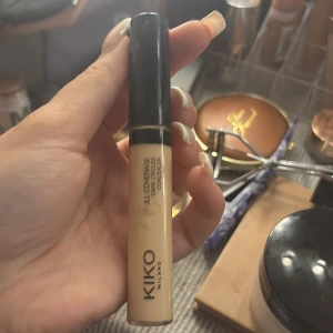KIKO Full Coverage Concealer - KIKO Milano Full Coverage Concealer i en ljus beige nyans. Kommer i en smidig tub med svart lock, perfekt för att täcka mörka ringar under ögonen och ge en jämn finish. Enkel att applicera med applikatorn direkt på huden.