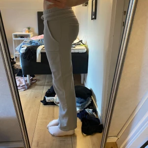 Gråa mjukisbyxor med raka ben - Säljer ett par gråa mjukisbyxor med raka ben och resår i midjan. Byxorna har stora fickor framtill och är gjorda i mjukt bomullsmaterial. Perfekta för chill dagar hemma eller när du vill vara bekväm men ändå se fräsch ut. 