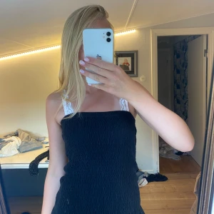 Svart kort kjol som funkar som tub topp - Supersöt svart kort kjol med smockad passform och volangkant nertill. Jätte fin kjol som kan användas som kjol men även som tub topp