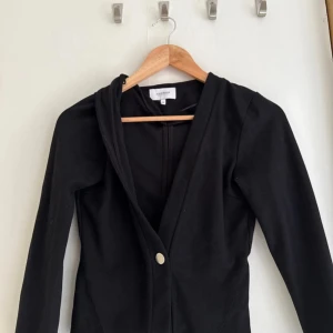 Svart kavaj från Alice Bizous XS - Svart kavaj från Alice Bizous i stilren design med lång ärm och en knapp framtill. Snygg passform och klassisk look, perfekt att slänga över en topp eller skjorta. 