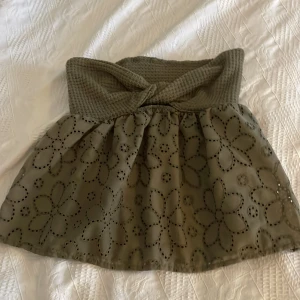 Grön topp  med blommönster - Snygg grön ärmlös topp med ett blommigt mönster. Toppen  har en volangdetalj och är perfekt för en stilren look. passar bra till olika tillfällen.Perfekt till sommaren.