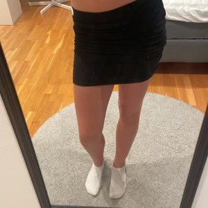 Svart tight minikjol från New Look - Svart, enkel och tight minikjol från New Look. Kjolen har en rak passform och bred resår i midjan för en bekväm känsla. Man kan bestämma själv hur lång man vill ha den vilket är perfekt. Materialet känns mjukt och stretchigt.