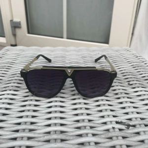 Snygga svarta och guldiga glasögon  -  Snygga glasögon i svart och guld med en svart båge och diskreta guldfärgade detaljer, perfekta för dig som vill ha en stilren men ändå lyxig känsla. 