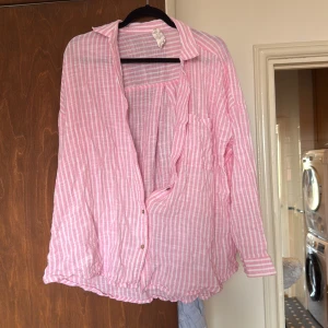 Rosa och vit randig skjorta från Body - Luftig och oversized skjorta från Body i rosa och vitt randigt mönster. 