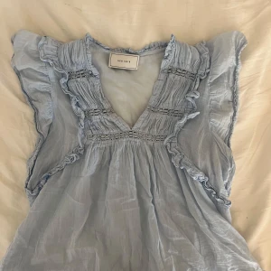 Ljusblå Neo Noir blus - superfin blus köpt på jackie, den är alltså äkta. lappen sitter endast fast på ena sidan och har gått upp på andra. storlek är lite oklar men skulle tro xs-s.