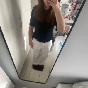 Vita linnebyxor - Säljer ett par fräscha vita linnebyxor med avslappnad passform och snörning i midjan. Byxorna har raka, vida ben och är perfekta för varma dagar. De är tillverkade i svalt linnematerial och har en enkel, stilren look. 