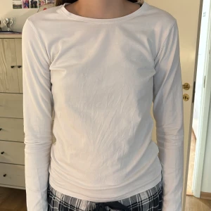 Vit långärmad tröja från Cubus - En basic vit långärmad tröja från Cubus i storlek S i mjuk bomull. Tröjan har rund halsringning och en slim passform som sitter snyggt mot kroppen. Perfekt att styla med jeans eller kjol för en clean look. Använd ett fåtal gånger.