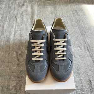 Grå Maison Margiela sneakers i mocka och skinn - Maison Margiela sneakers i grå mocka och skinn. Används endast ett par gånger. Hör av er vid eventuella frågor!