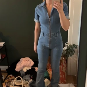 Jumpsuit Mango  - Snygg blå jeans jumpsuit med korta ärmar från mango. Helt ny med prislappen kvar, slutsåld på hemsidan 