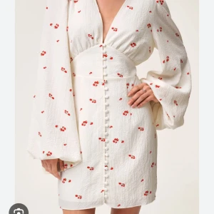Adoore klänning   - Kort vit klänning med röda blommor från Adoore, använd ett fåtal gånger och är i mycket bra skick, storlek 34. Jag har vanligtvis 36/S i klänningar och den passar mycket bra. Nypris: 1495kr (Pris kan diskuteras)