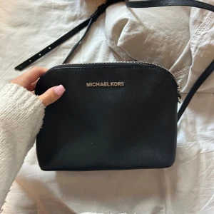 Svart axelväska från Michael Kors - Handväska från Michael kors med långt axelband.💕jättefint skick!