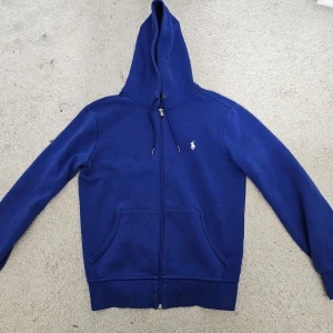 Polo Ralph Lauren kofta  - Säljer min polo Ralph Lauren kofta som har blivit för liten. Den är köpt på polo Ralph Lauren butiken men har tyvärr inte kvar kvitto. Det är storlek xs oxh en härlig blå färg pefterkt till hösten. Den är i skick 8/10. Skriv vid minsta fundering. Nypris 2199kr