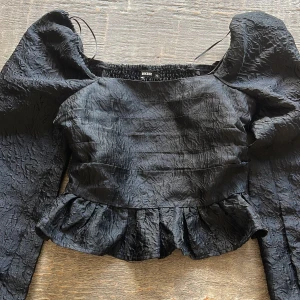 Svart volangblus från BikBok - Supersnygg svart blus från BikBok med puffiga långärmar och volang nertill🤍använd 1-2 gånger