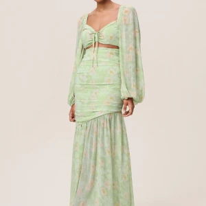 Adoore Ljusgrön blommig långklänning strl 34 - Superfin ljusgrön långklänning med blommigt mönster, v-ringning och knyt framtill. Klänningen har långa puffärmar och volangdetalj nedtill. Perfekt för sommarens tillfällen! Nypris: 1695kr