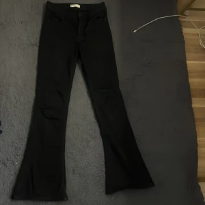 Svarta bootcut jeans från g perfect jeans - Svarta jeans från g perfect jeans i bootcut-modell. Byxorna har klassiska fickor både fram och bak och är tillverkade i ett stretchigt material som sitter skönt. Perfekta för dig som gillar en tidlös och enkel stil.