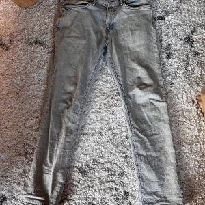 Ljusgråa jeans Regular fit från H&M - Säljer ett par ljusblå jeans från H&M i modellen Regular fit. Jeansen har klassisk femficksdesign, raka ben och normal passform. Perfekta för en avslappnad stil och funkar året runt.