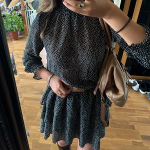 Svart vit prickig volang transparent klänning S - Snyggaste klänningen, var super populär för flera år sen då jag köpte den! Svart med vita prickar med fyllig volang kjol med smock i midjan som formar snyggt. Lite transparent överdel med fina detaljer🧸storlek S och använd ca 5 ggr men används inte mer tyvärr! (Mini/midi)