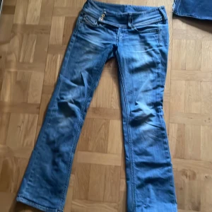 diesel jeans med låg midja - Säljer ett par jättefina blå bootcut jeans med låg midja från diesel. modellen cherock. Jeansen har klassiska fickor både fram och bak samt snygga slitningar för en cool look. midjemått tvärsöver:ca 38 cm innerbenslängd: ca 81 cm