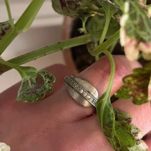 Bred äkta silverring med stenar - Säljer en bred ring i äkta silver (925) med en rad infattade stenar längs mitten. Ringen har en unik, rundad form och är ca 2 cm i diameter. Perfekt för dig som gillar statement-smycken! Lite repig på vissa ställen.