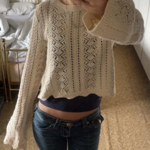 Beige stickad tröja  - Säljer en beige stickad tröja från Amisu med fint hålmönster och lång ärm. Tröjan är croppad och har en rund halsringning. Perfekt för lager-på-lager och ger en mysig känsla till din outfit. Aldrig använd!