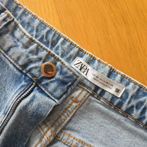 Ljusblå jeansbyxor från Zara - Säljer ett par ljusblå jeansbyxor från Zara med klassisk femficksdesign och gylf med dragkedja och knapp. Jeansen har en normal passform och raka ben, perfekta till vardags. Snygga kontrastsömmar och tidlös look.😍💘