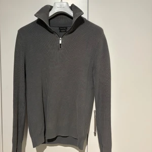 Grå stickad tröja med dragkedja från Massimo Dutti - Säljer en stilren grå stickad tröja från Massimo Dutti i extra fin bomull. Tröjan har halv dragkedja vid halsen och långa ärmar. Perfekt för lager-på-lager och enkel att matcha med olika outfits. Storleken är L men passar mycket bra för M. 😁