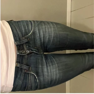 Mörkblå jeans från Lee - Säljer ett par jeans från lee, själva modellen är har en ganska ”sliten” look, de har en liten slits vid foten och de är ganska utsvängda men raka, skriv för fler bilder eller frågor, pris kan diskuteras