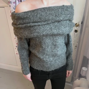 Grå offshoulder stickad tröja - Säljer en grå stickad tröja med bred offshoulder-krage. Alpacka, akryl. Använd en gång