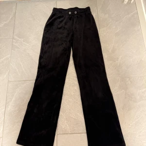 Svarta vida mjukisbyxor - Mysiga svarta mjukisbyxor med vida ben och resår i midjan. Perfekta för en avslappnad stil och sköna att ha på sig hela dagen. Byxorna har en enkel design utan synliga detaljer förutom resåren upptill. (Passar storlek S)
