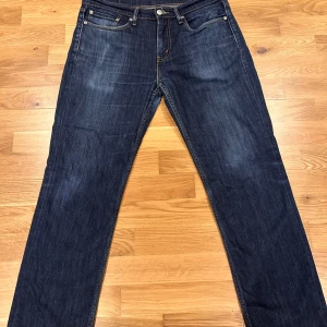 Levi's 514 jeans i mörkblå denim - Säljer ett par klassiska Levi's 514 jeans i mörkblå tvätt. Byxorna har raka ben, fem fickor och klassisk Levi's-lapp bak i midjan. Perfekta för dig som gillar en tidlös och enkel jeansstil. Endast använda några få gånger. Ny pris 1 100 kr, pris kan diskutera. Storlek 32/30