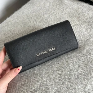 Väska till bal - Säljer min plånbok/mini väska från Michael Kors. Jag använde min på balen som portmonä. Jag fick plats med min mobil (IPhone 13). Finns fack för kort osv.💗Nypris 2000 kr