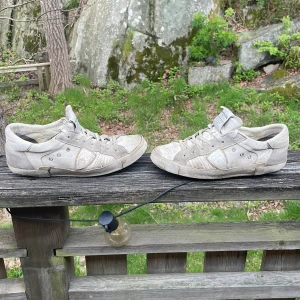 Vita sneakers från Philippe Model - Säljer ett par vita sneakers från Philippe Model med klassisk design och rund tå. Skorna har snörning och är tillverkade i skinn med diskreta detaljer på sidorna. Perfekta för dig som gillar stilrena och tidlösa sneakers. En 42 en 40 märker inte skillnad på de så mycket köpta på kicksnstuff.