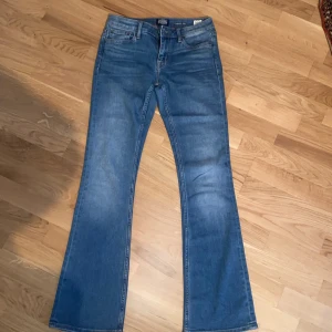 Blå utsvängda jeans  - Snygga blå jeans från med klassisk utsvängd-passform. Jeansen har fem fickor, normalhög midja och stängs med dragkedja och knapp. Perfekta för dig som gillar en tidlös denimlook. Kan sitta lite låg midjan om man vill det ser fortfarande super ut. Bästa materialet någonsinnnn!!!!🫶🏼