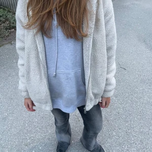 Beige teddyjacka med dragkedja - Mysig beige teddyjacka med dragkedja framtill. Jackan har en avslappnad passform och är perfekt för kyligare dagar. Fodrad insida och mjukt material som ger en skön känsla.