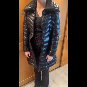 Svart lång dunjacka från Moncler - Säljer min flickväns jacka. Säljs pga att den bara tar plats och aldrig används. Det är en lång dunjacka från Moncler med hög krage och dragkedja framtill. Priset är inte hugget i sten så kom gärna med förslag! Storleken är XS/S