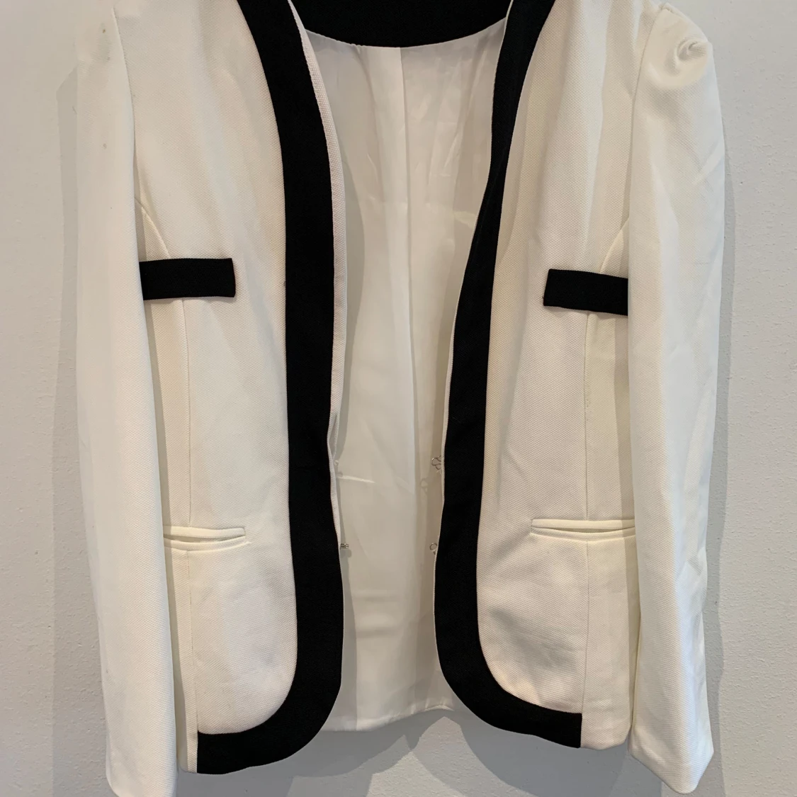 Vit kavaj med svarta detaljer