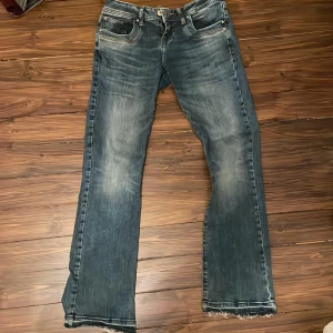 Blå jeansbyxor från LTB Valerie - Säljer ett par low rise bootcut blå jeansbyxor från LTB, modell Valerie. Byxorna har boot cut stil, slitna detaljer och fransig nedtill. Perfekta för en avslappnad stil. Använder inte längre. 