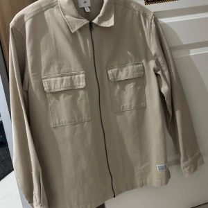 Overshirt  - Beige clean overshirt knappt använd i storlek L.