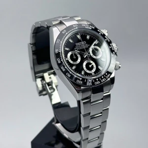 Seiko Daytona Mod Svart - Nu är denna Daytona-mod färdigbyggd och till salu! (Custom-made.) Diameter: 40 mm | Tjocklek: 12 mm | Seiko VK63 hybridurverk | Safirglas (AR-behandlat) | 316L stålboett & armband (säkerhetslås) | Keramisk bezel | Skruvad krona | Luminova | 3 ATM | Solid baksida | Justerbar: 14,5–22 cm | Funktionell kronograf & subdials. Klocklåda & verktyg ingår. Frågor? DM!