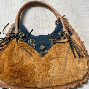 Handväska - Riktigt unik handväska! Mörkblått jeansmaterial och brun päls. Den har även små silverhängen och fransar på sidorna💙