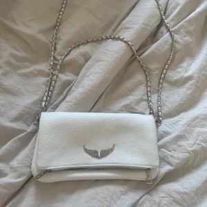 zadig & voltaire väska - Säljer en stilren vit zadig & voltaire axelväska med silverfärgad kedja. öppen för byten och pris går att diskutera🥰